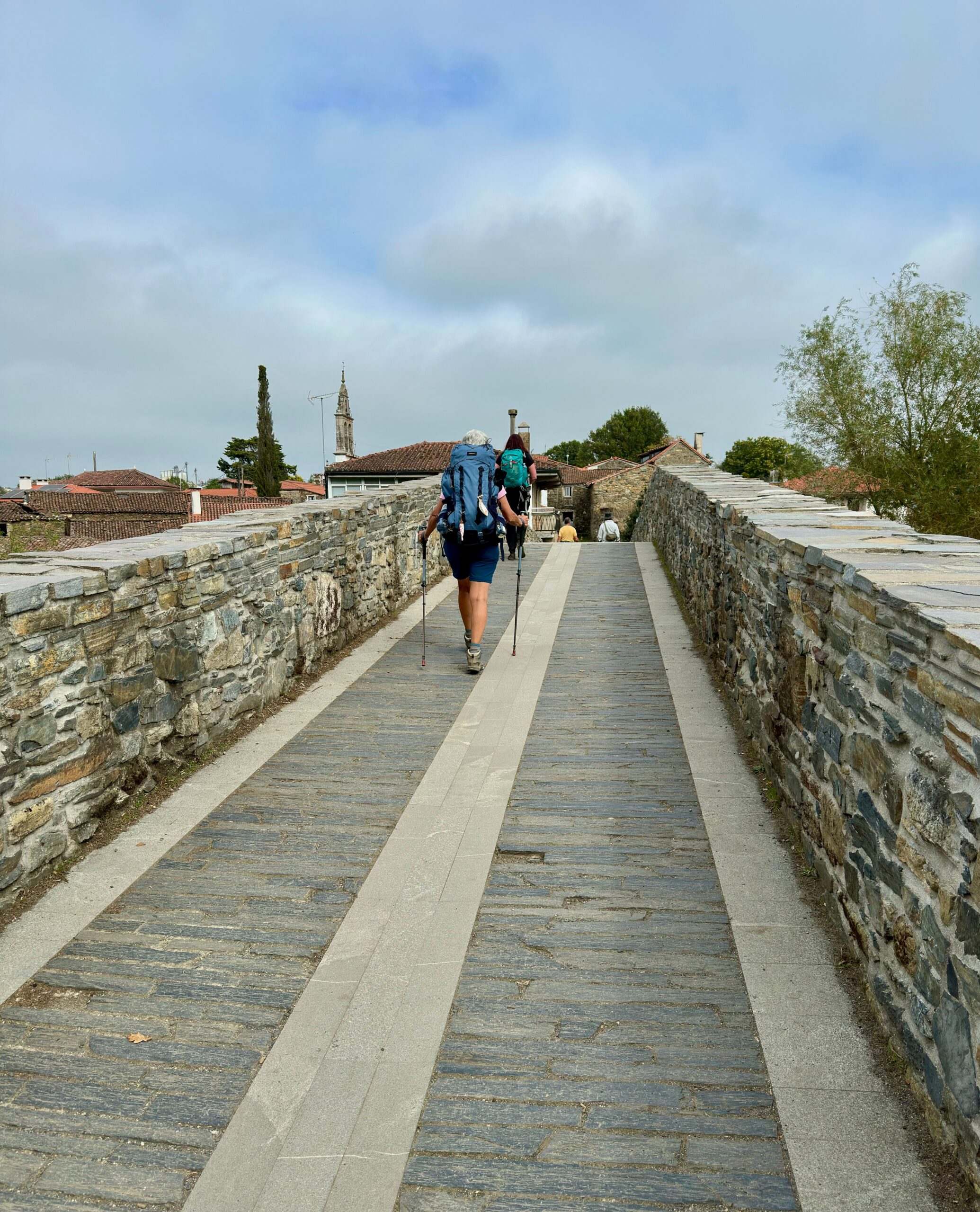 Camino – pútnik kráčajúci po kamennom moste
